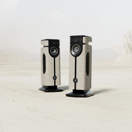 Pair of luxury speakers in a light-colored finish standing in a desert-like setting