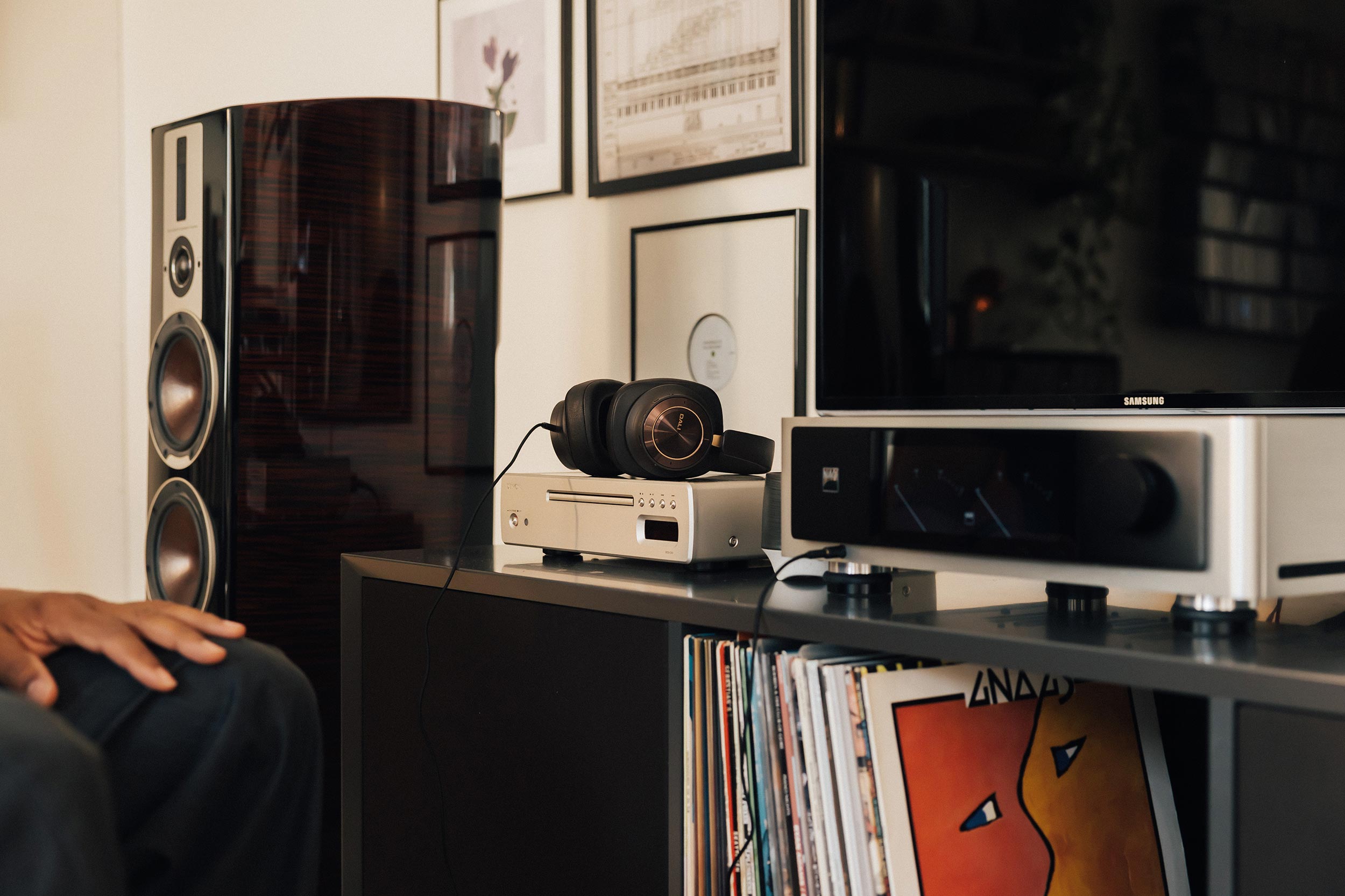 Audio equipment including headphones on a media console next to a speaker